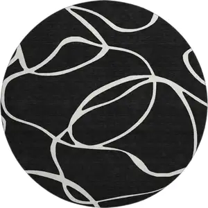 Photo of 8' Black And Ivory Abstract Washable Round Rug With UV Protection