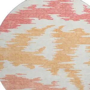Photo of 8' Coral Orange And Gold Abstract Washable Round Rug With UV Protection