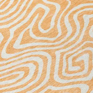 Photo of 8' Peach And Ivory Round Abstract Washable Indoor Outdoor Area Rug