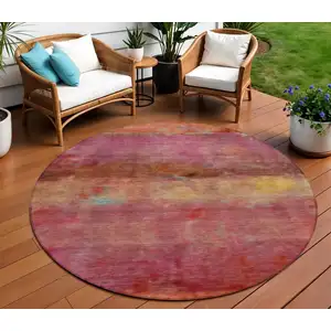 Photo of 8' Pink Orange And Gold Round Abstract Washable Indoor Outdoor Area Rug