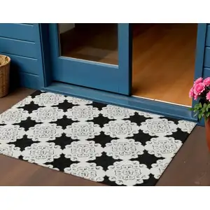 Photo of Black And Ivory Quatrefoil Washable Indoor Outdoor Area Rug