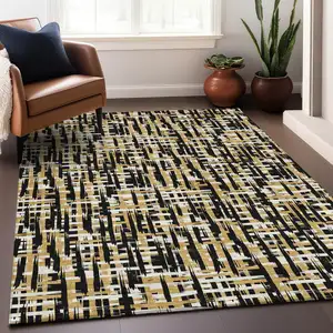 Photo of Black Gold And Ivory Abstract Washable Indoor Outdoor Area Rug