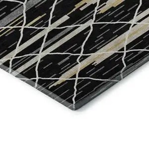 Photo of Black Gold And Ivory Striped Washable Area Rug With UV Protection