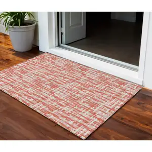 Photo of Coral Pink And Ivory Abstract Washable Indoor Outdoor Area Rug
