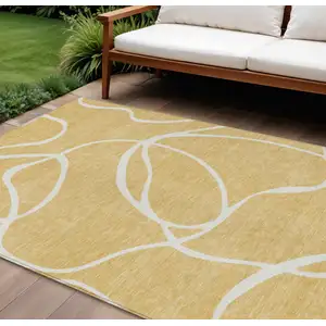 Photo of Gold And Ivory Abstract Washable Indoor Outdoor Area Rug