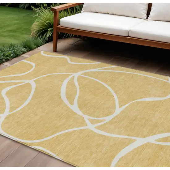 Gold And Ivory Abstract Washable Indoor Outdoor Area Rug Photo 1