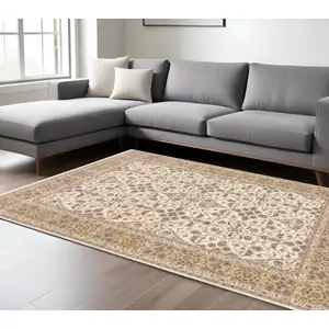 Photo of Ivory And Gold Oriental Power Loom Stain Resistant Area Rug With Fringe