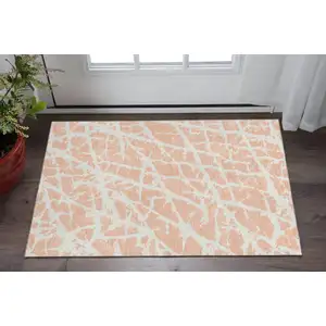 Photo of Peach And Ivory Abstract Washable Area Rug With UV Protection