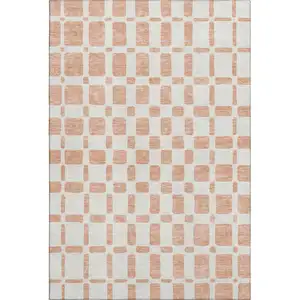 Photo of Peach And Ivory Geometric Washable Area Rug With UV Protection