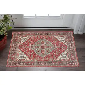 Photo of Red Gray And Ivory Wool Floral Hand Knotted Distressed Stain Resistant Area Rug With Fringe