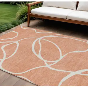 Photo of Salmon And Ivory Abstract Washable Indoor Outdoor Area Rug