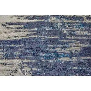 Photo of Tan Blue And Ivory Abstract Power Loom Distressed Area Rug