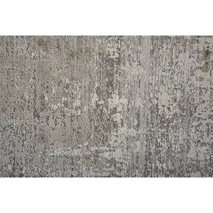 Photo of Tan Ivory And Gray Abstract Power Loom Distressed Area Rug With Fringe