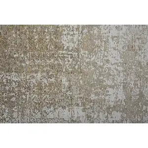 Photo of Taupe Ivory And Gold Abstract Power Loom Distressed Area Rug With Fringe