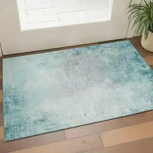 Photo of Teal And Ivory Abstract Washable Area Rug With UV Protection
