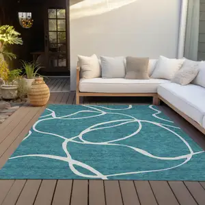 Photo of Teal Blue And Ivory Abstract Washable Indoor Outdoor Area Rug
